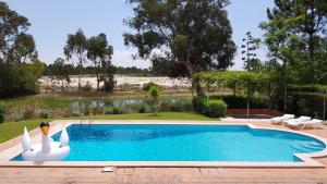 a swimming pool with two swans in a yard at Villa Sequoia - Beach and Lake Private Holidays in Troia