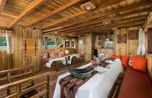 a room with a table in a wooden house at Plataran Phinisi Felicia, a Luxury Private Cruise in Labuan Bajo