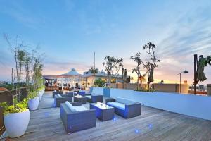 a rooftop patio with blue couches on a building at de Vins Sky Hotel Seminyak in Seminyak