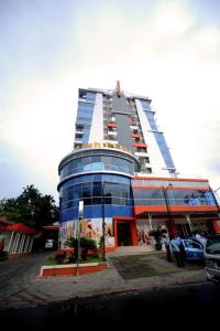 un edificio alto con un coche aparcado delante de él en High Point Serviced Apartment en Surabaya