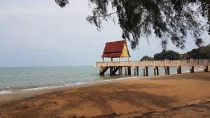 a pier on the beach next to the ocean at LOT7040 in Melaka