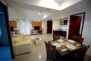 sala de estar con mesa y sillas y cocina en High Point Serviced Apartment en Surabaya