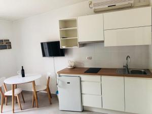 a kitchen with white cabinets and a table and a sink at Guest House Marija in Bol