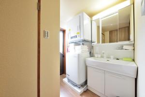a kitchen with a white refrigerator and a sink at Shiki Tofukuji in Kyoto +47 photos