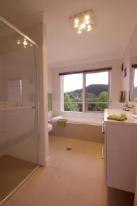 a bathroom with a shower and a toilet and a window at Cadence at Bright - Luxury accommodation in Bright
