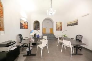 una habitación con mesas y sillas y una escalera en Madonie Holidays, en Cefalú