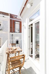 Un patio con una mesa y sillas en un balcón. en 1898 Home & Suites, en Lisboa