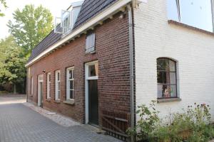 a red and white brick building with a window at Het Aambeeld in Wanroij