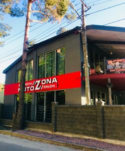 a building with a red sign in front of it at Motozona in Briukhovychi