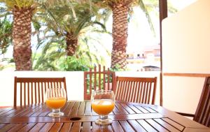 ロス・カンカホスにあるVivienda Vacacional Los Balconcitosの木製テーブルに座るオレンジジュース2杯