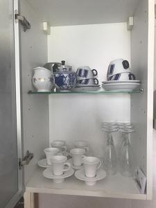 巴韋諾的住宿－Appartamento LA DULCE VIDA，厨房里装满了杯子和碟子的架子