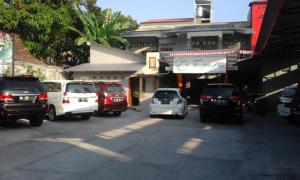 a group of cars parked in a parking lot at Tanjung Inn in Wonosari