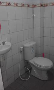 een badkamer met een toilet en een wastafel bij Tanjung Inn in Wonosari