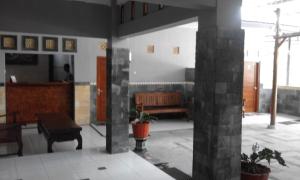eine Lobby mit einem Tisch und einer Bank in einem Gebäude in der Unterkunft Tanjung Inn in Wonosari