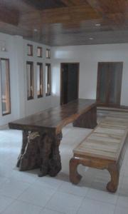 een grote houten tafel en een bank in een kamer bij Tanjung Inn in Wonosari