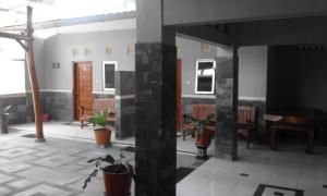 a room with tables and chairs and a piano at Tanjung Inn in Wonosari