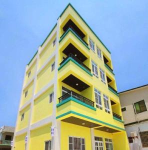un bâtiment jaune avec des balcons sur son côté dans l'établissement Taitung Sea Wall Homestay, à Taïtung