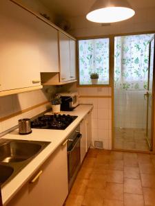 kuchnia ze zlewem i kuchenką górny piekarnik w obiekcie Piso frente la playa de Valdelagrana w mieście El Puerto de Santa María