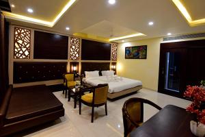 um quarto com uma cama, uma mesa e cadeiras em Hotel Dayal Shree Paradise em Bhopal