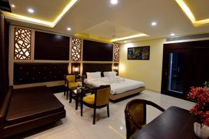 a bedroom with a bed and a table and chairs at Hotel Dayal Shree Paradise in Bhopal