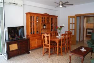 sala de estar con mesa de comedor y TV en Playa Delicias, en Águilas