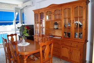 a dining room table with a large wooden cabinet at Playa Delicias in Águilas