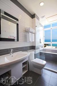 台東市的住宿－台東海堤海景民宿，浴室配有盥洗盆、卫生间和浴缸。
