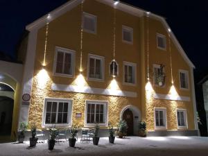 a large yellow building with lights on it at Gasthof-Pension Schwarzer Bär in Waidhofen an der Ybbs