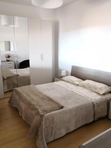 a white bedroom with a large bed and a mirror at Appartamento Sicilia vicino Caltagirone - Niscemi in Niscemi
