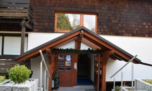 Una casa con una puerta con una corona. en Pension am See, en Schluchsee