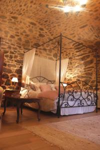 1 dormitorio con cama con dosel en una pared de piedra en Le Studio, en Entraygues-sur-Truyère