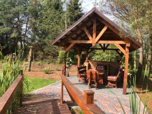 a wooden gazebo with a table and chairs at Agroturystyka Omelia in Człuchów