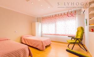 a bedroom with two beds and a yellow chair at Pueblo evita in Benalmádena