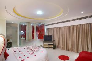 Fahrenheit Hotels & Resorts في باغا: غرفة نوم بسرير ابيض وعليه ورد