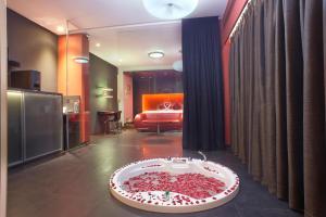 Fahrenheit Hotels & Resorts في باغا: غرفة مع حوض استحمام مملوء بتلات حمراء