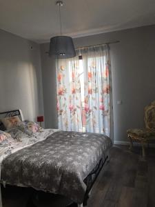 een slaapkamer met een bed en een groot raam bij Rubinowe Apartamenty in Sandomierz