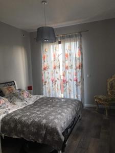 a bedroom with a bed and a large window at Rubinowe Apartamenty in Sandomierz