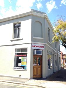 een wit gebouw met een deur in een straat bij Shingo's Backpackers in Adelaide