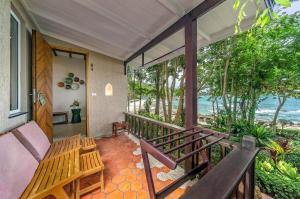 a porch with a bench and a view of the ocean at Samed Villa Resort in Ko Samed