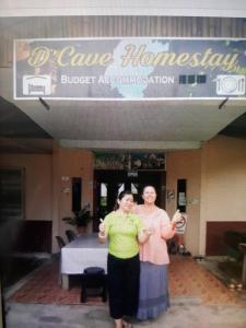 two women standing in front of a building at Mulu D cave homestay in Mulu
