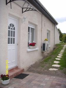 een huis met twee ramen en een deur met bloemen erop bij le gite d'olhain in Fresnicourt-le-Dolmen