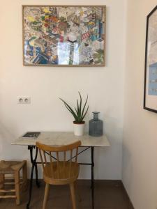 a table with a potted plant and a painting on the wall at Le Studio des Artistes in Marseille