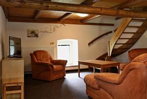 a living room with two chairs and a table at Chaloupka Slaměnka in Loučná pod Klínovcem