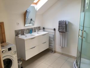 a bathroom with a sink and a washing machine at Le Loft in Lacanau