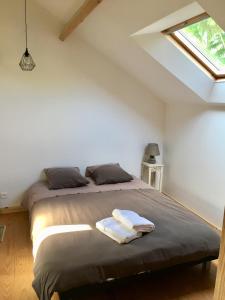 a bedroom with a large bed with a window at Le Loft in Lacanau