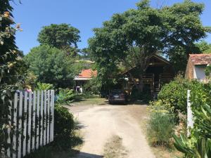 a driveway to a house with a fence at Le Loft in Lacanau