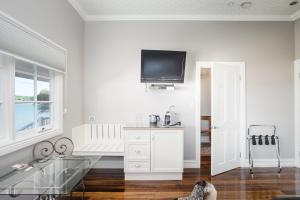 un soggiorno bianco con TV a parete di The Ark Stanley Luxury Bed and Breakfast a Stanley