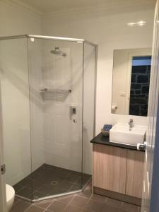 uma casa de banho com um chuveiro e um lavatório. em Port Boutique Accommodation em Port Fairy