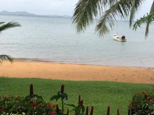 a boat in the water next to a beach at Amber Sands Beach Resort in Ko Chang