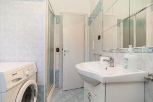 een badkamer met een wastafel en een wasmachine bij Appartamento Tony in Sperlonga